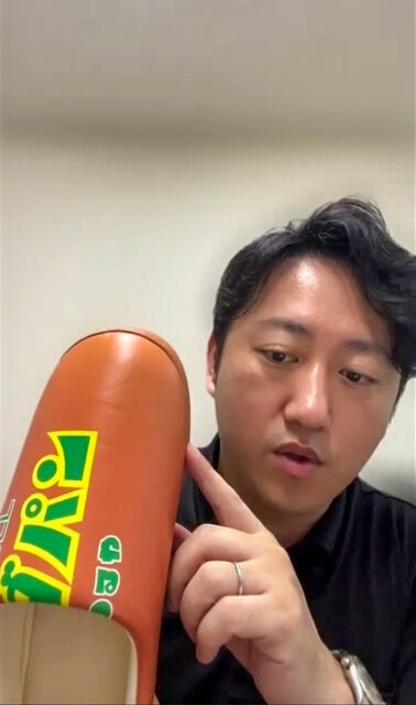 サラダパンノクツを手に持つ、まるほ商事株式会社　方橋孝貴社長